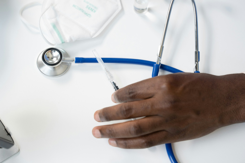 Doctor holding an injection and a stethoscope