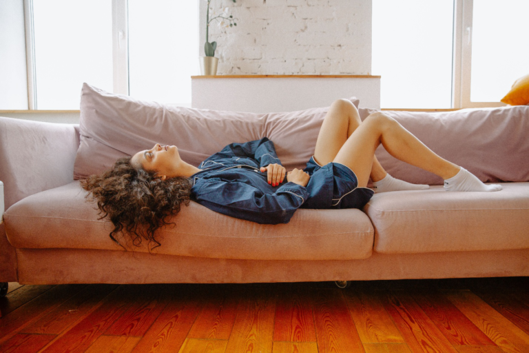 Woman suffering from stomach pain on couch