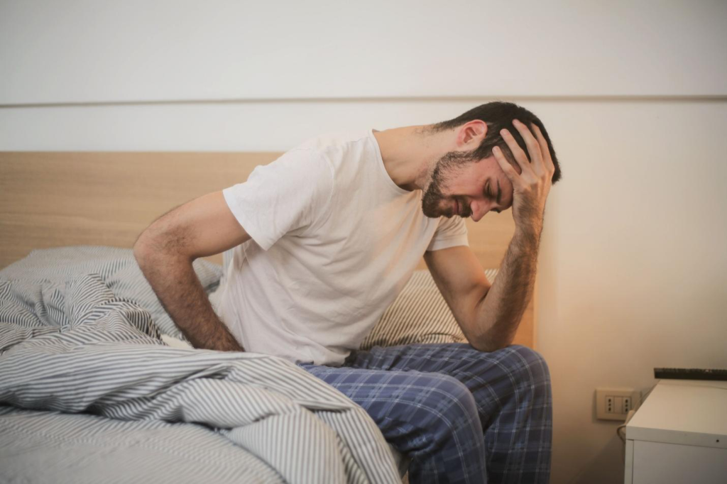 Young man in sleepwear experiencing discomfort in the morning